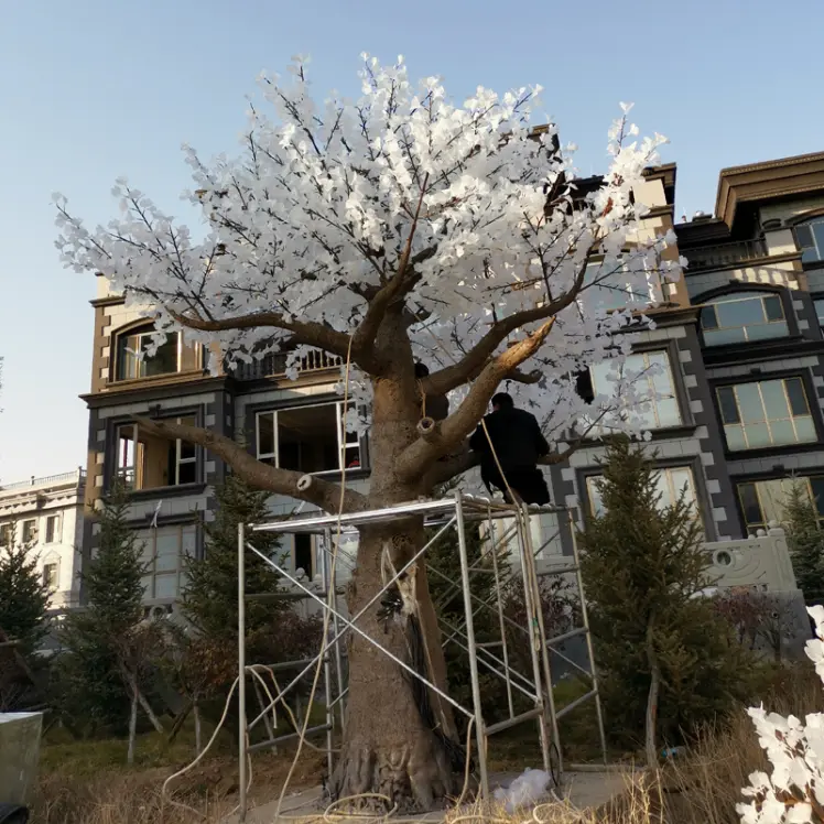 Construction workers lifting large RGB Light Tree with crane for plaza outdoor lighting installation