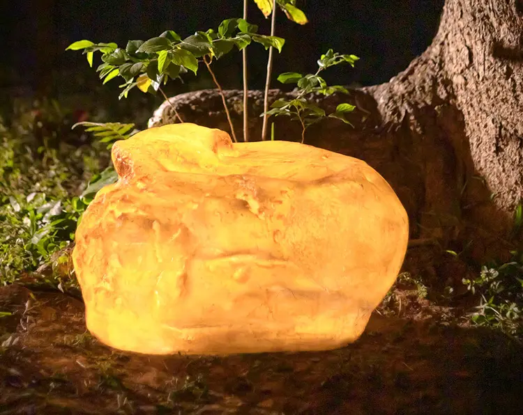 LED stone light closeup, natural texture glowing rock garden light